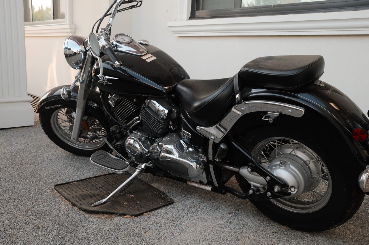 A black Yamaha V-Star Classic cruiser with chrome detailing, seen from the rear three quarter.