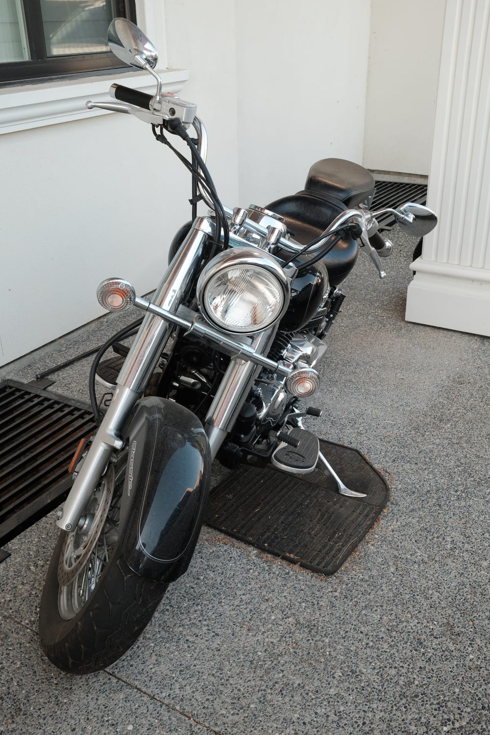 A black Yamaha V-Star Classic cruiser motorcycle with heavy chrome, spoked wheels and a wide saddle.